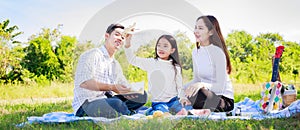 Happy family picnic. Asian parents Father, Mother and daughter playing the toy airplane and have enjoyed ourselves together whil