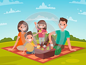 Happy family on a picnic. Dad, mom, son and daughter are resting