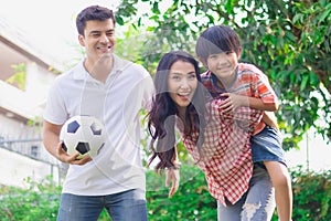 Happy family play soccer as activity together in yard at home