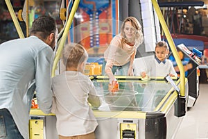 happy family playing air hockey together in entertainment center