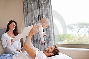 Happy family playing with baby in air, bedroom and fun of love, care and quality time to relax together at home. Mom