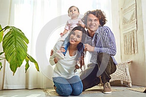 Happy family playing with baby at home.