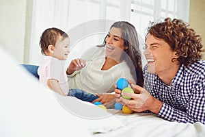 Happy family playing with the baby in the room. Young mother and