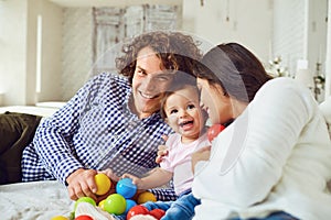 Happy family playing with the baby in the room. Young mother and