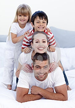 Happy family playing in bed together