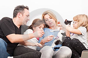 Happy family playing with cat or pet