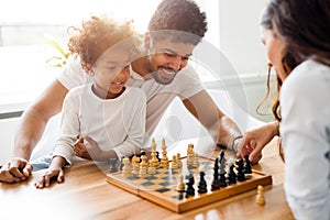 Happy family playing chess together