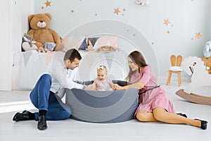 Happy family playing with colorful balloons in the children`s room at home