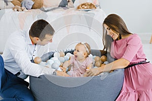 Happy family playing with colorful balloons in the children`s room at home