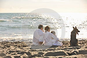 Happy family playing with dog on beach