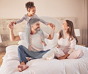 Happy family while playing and fun in bed at home together in the morning. Mother, father and girl or daughter laughing