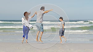 Happy family playing and having fun on the beach ocean. Slow Motion. Family, Freedom and Travel concept.