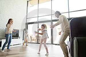 Happy family playing hide and seek game in luxury house