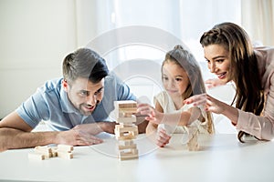 Happy family playing jenga game at home photo