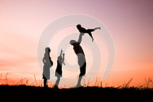 Happy family playing on nature summer silhouette