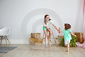 Happy family playing into new home. Mother and daughter having f