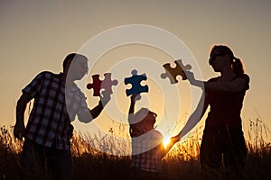 Happy family playing at the park at the sunset time