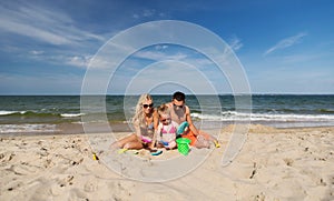 Happy family playing with sand toys on beach