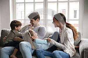 Happy family playing on sofa at home.