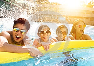 Happy family playing in swimming pool