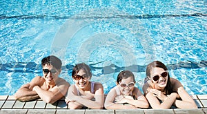 Happy family playing in swimming pool photo