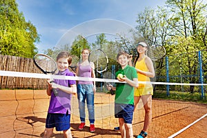 Happy family playing tennis on court