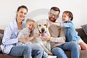 Happy family playing with their favorite pet dog   at home