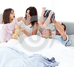 Familia feliz común sobre el una cama 