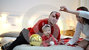 Happy family playing together: mother, father and 1 year old baby girl. Christmas holiday