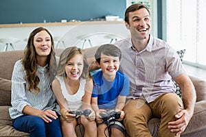 Happy family playing video games together in living room