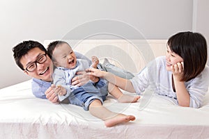 Happy family playing on white bed