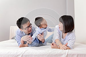 Happy family playing on white bed