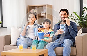 Happy family with popcorn watching tv at home