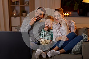 Happy family with popcorn watching tv at home