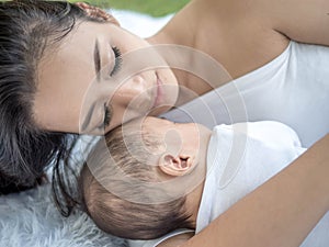 Happy family, portrait of beautiful young asian mother kissing her newborn baby with love. Healthcare and medical love