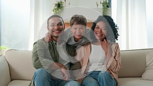 Happy family portrait Caucasian little boy loving child hugging multiracial parents African American mother and father