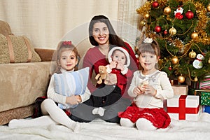 Happy family portrait in christmas decoration, winter holiday concept, decorated fir tree and gifts