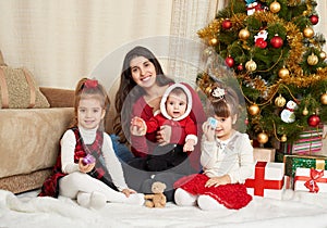 Happy family portrait in christmas decoration, winter holiday concept, decorated fir tree and gifts