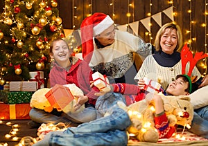 Happy family posing in new year or christmas decoration. Children and parents. Holiday lights and gifts, Christmas tree decorated