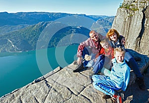 Happy family on Preikestolen massive cliff top (Norway)