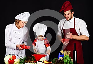 Happy family preparing breakfast together. Homemade food. Parents teaching little boy to cook healthy food. Mother