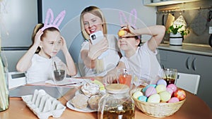 Happy family preparing for Easter. Cute little girls wearing bunny ears takes selfie photo on Easter day.