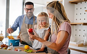 Happy family preparing healthy food together in kitchen. People happiness cooking concept