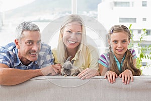 Happy family with rabbit on sofa at home