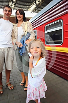 Happy family at railway station, focus on daughter