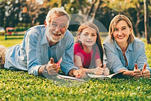 Happy family read books together in park garden.