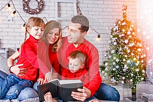 Happy family reading a book at home at christmas