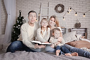 happy family reading a book at home at christmas