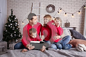 happy family reading a book at home at christmas