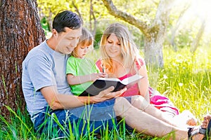 Happy family reading a book on the nature of the Bible